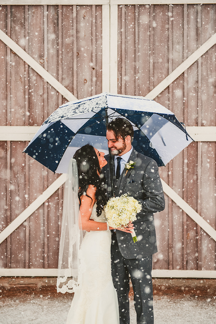 bride and groom looking into each others eyes in a snowstorm 