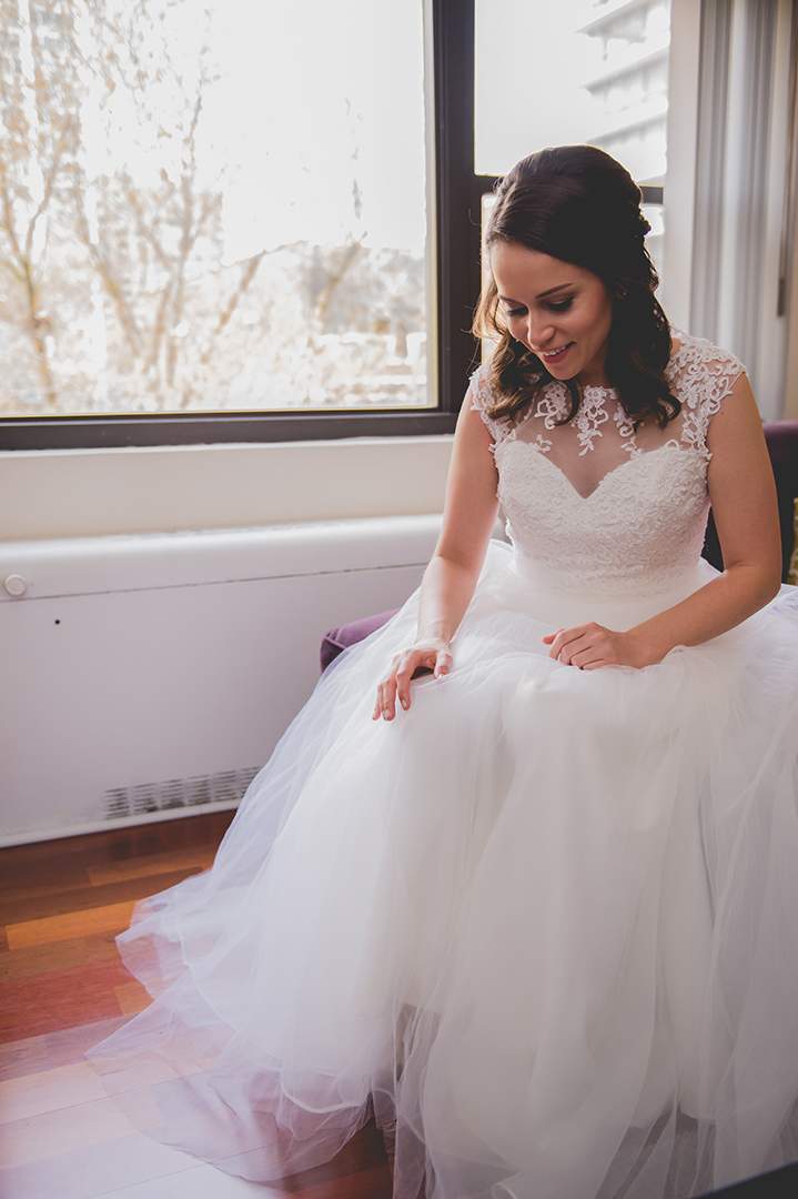 bride putting on shoes in her beautiful white wedding dress