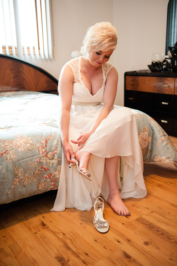 a bride putting on her shoes before her wedding