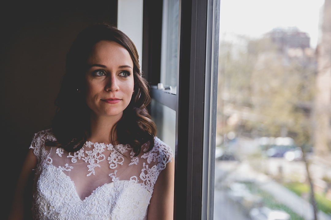 bride looking out her city window on her wedding day
