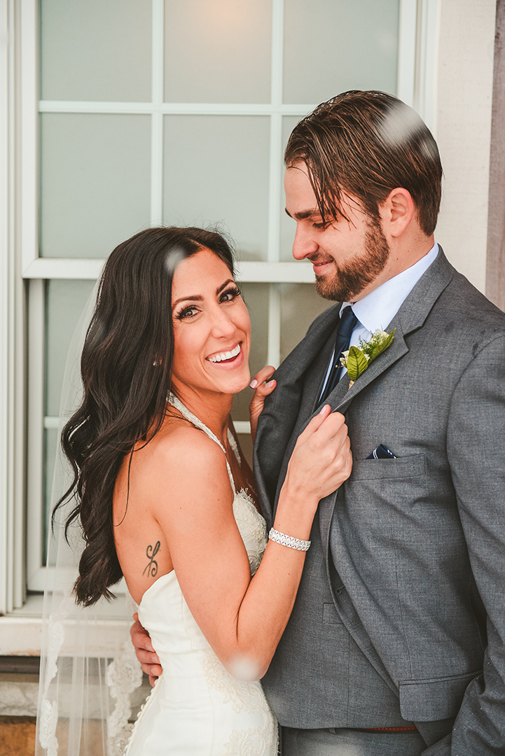 A woman laughs as her husband looks at her in the snow