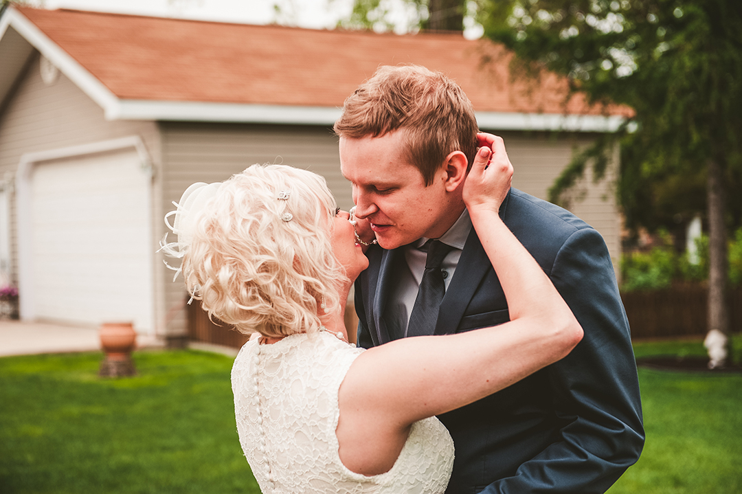 a bride and groom kissing during their first look at their Naperville home