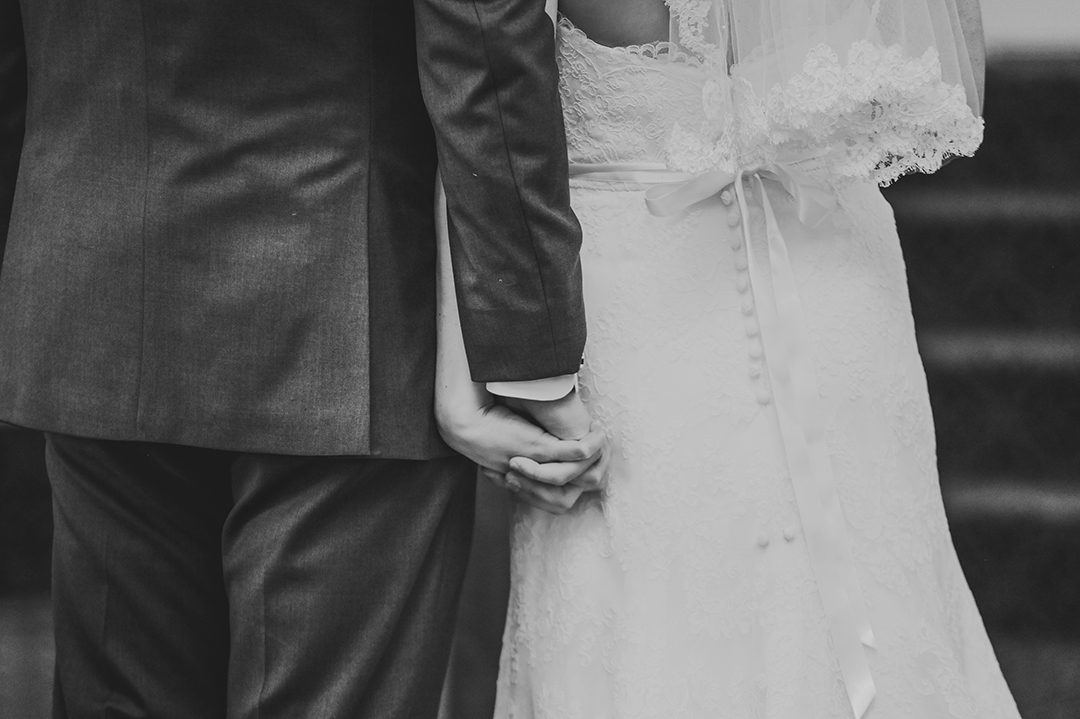husband and wife holding hands on wedding day