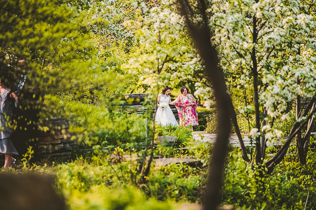 bride walking with her mother in the trees on her wedding day