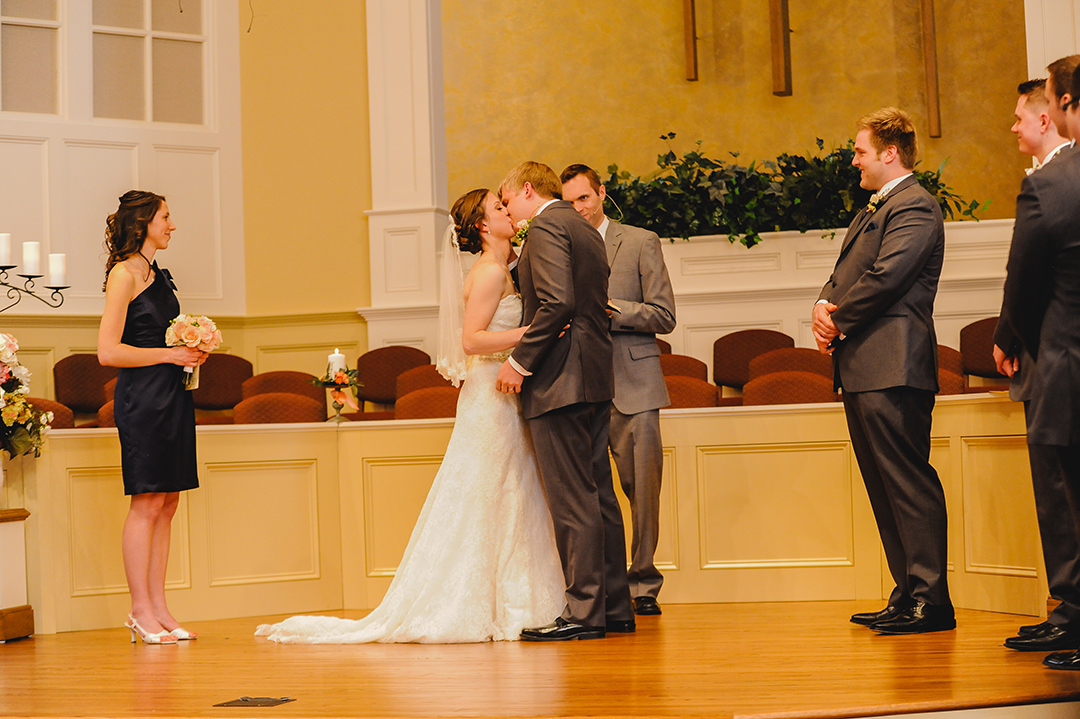 a bride and grooms first kiss at family church