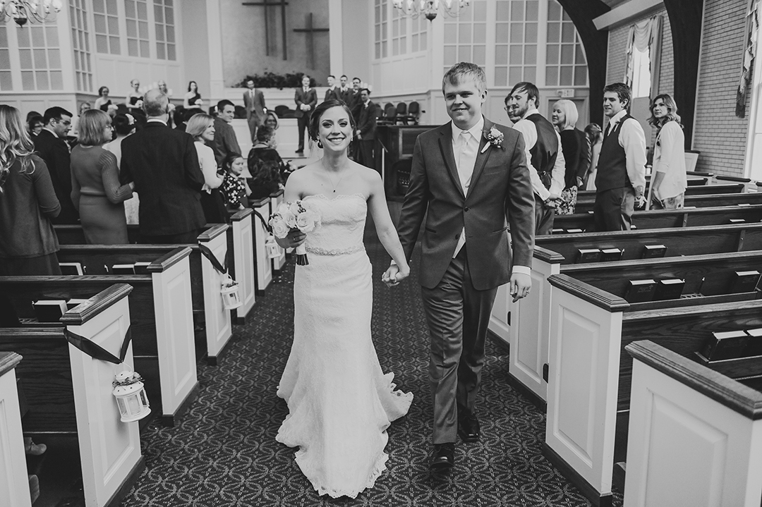 groom and wife walking down church aisle