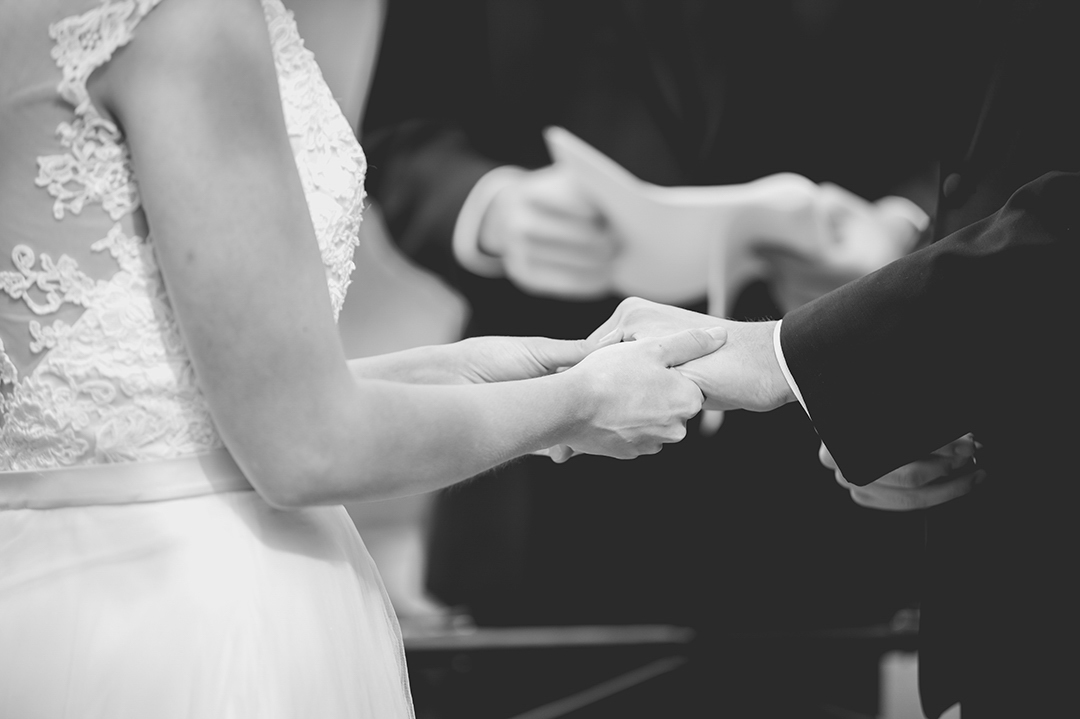 close up of bride holding grooms hand