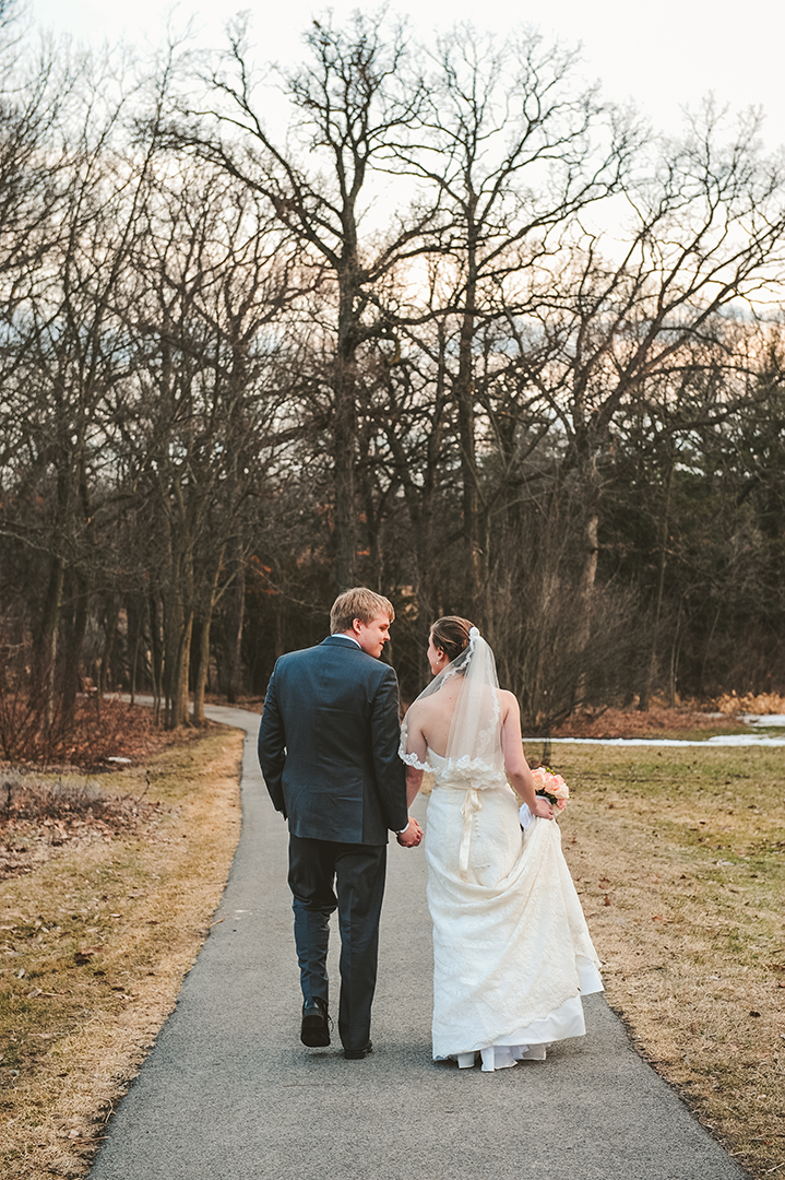 a couple walking in the woods on their wedding day