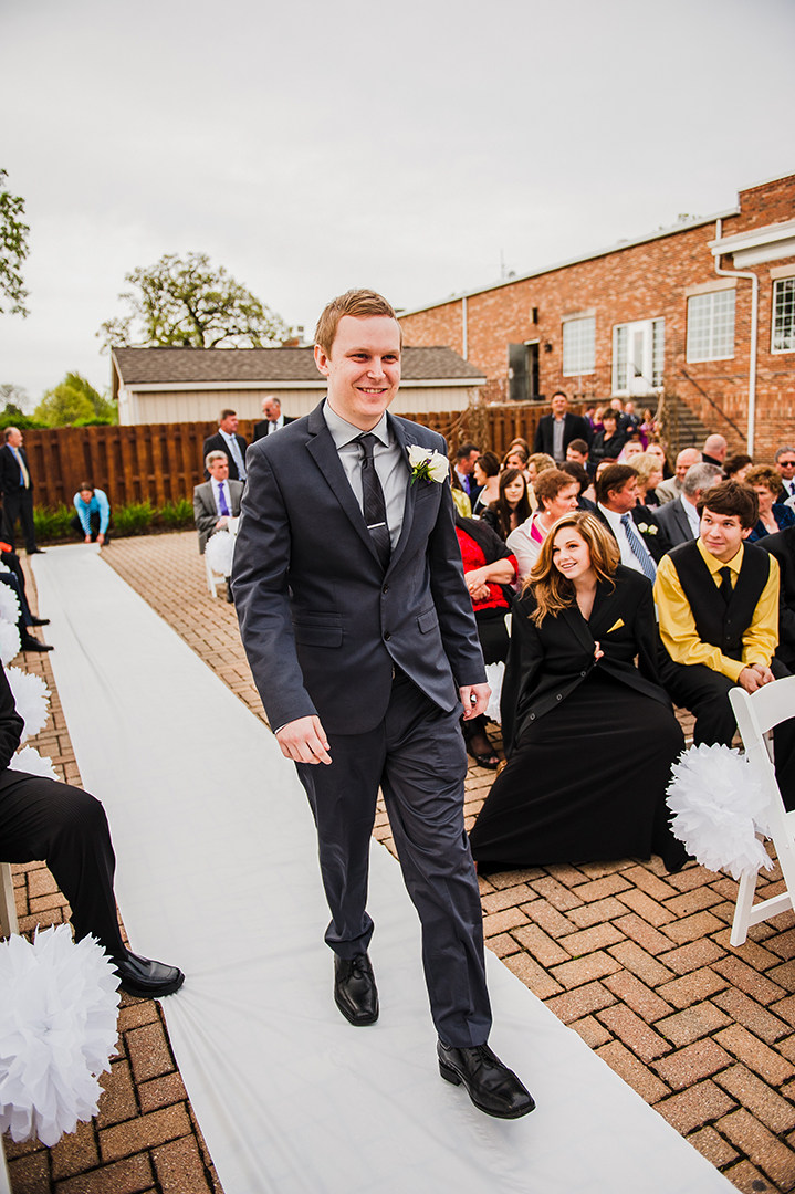 a groom walking down path to wedding