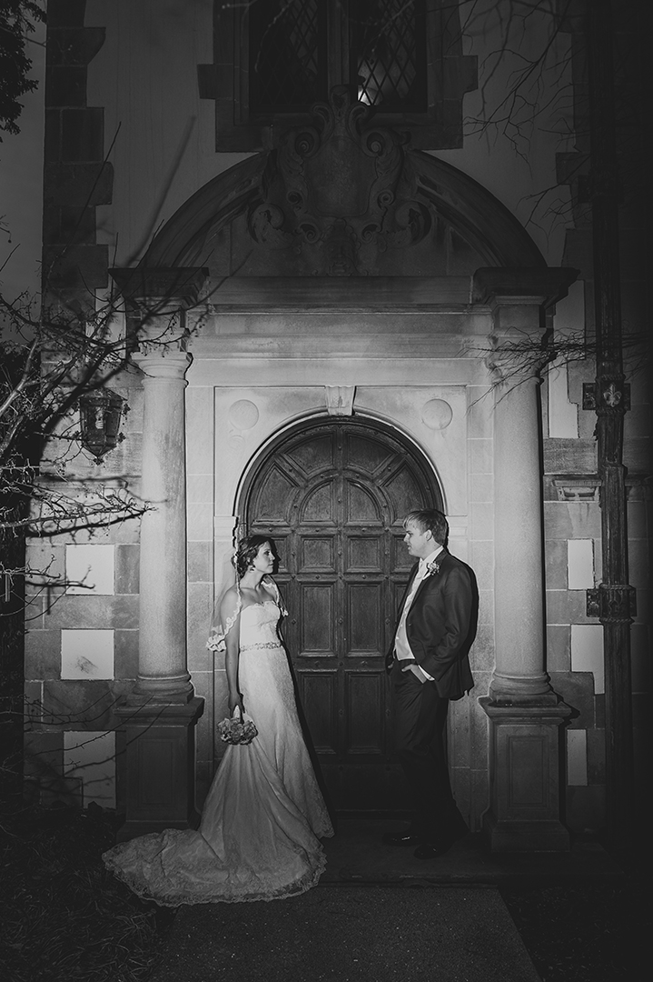 a couple standing in front of a old door 