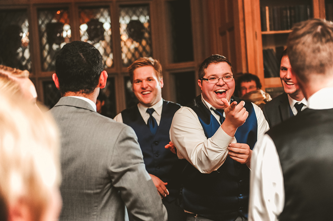 a man laughing while dancing at a wedding reception