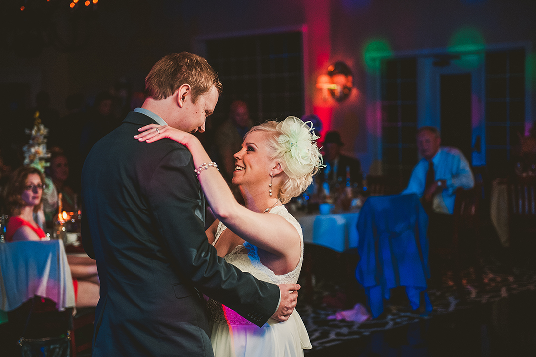 a bride and groom looking at each other during their first dance