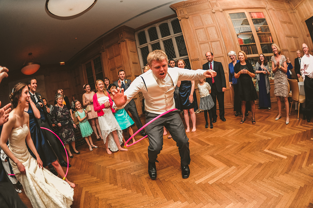 a groom dancing with a hoola hoop at his wedding reception