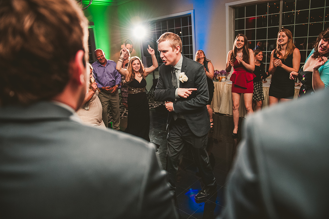 groom dancing on a packed dance floor at his wedding reception