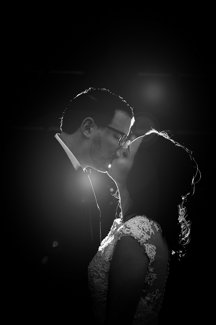silhouette of newlyweds kissing at wedding reception