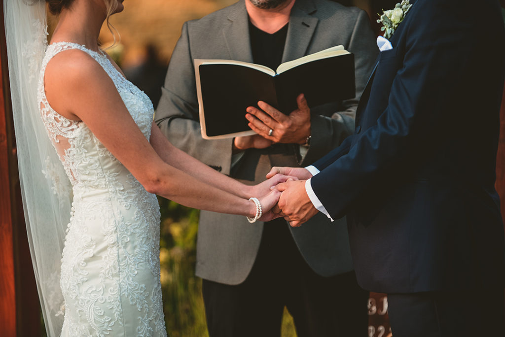 A detail of a bride and groom holding hands during their Naperville wedding.