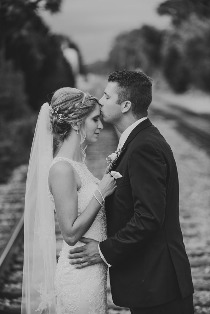 A groom kissing his brides head at a wedding in Plainfield Illinois.