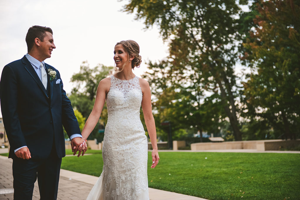 A bride and groom walking and laughing at the Public Landing in Lockport.