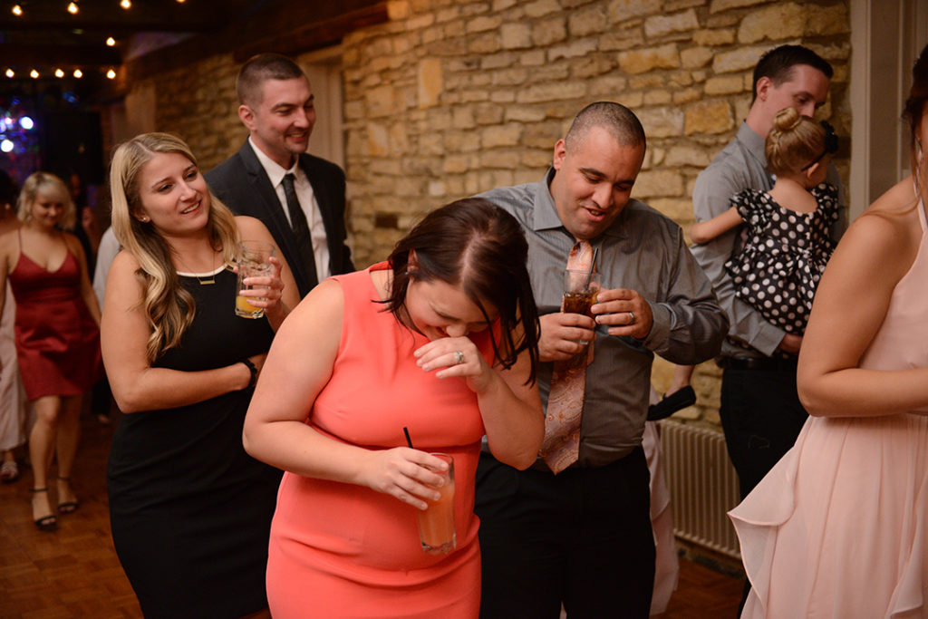 A woman laughing while dancing with friends at a Naperville wedding.