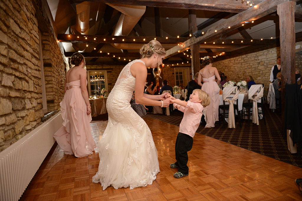A bride and a little boy dancing at a Naperville wedding.