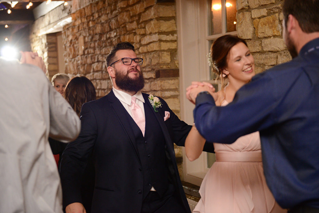 A groomsman making a funny face while dancing at the Public Landing in Lockport.