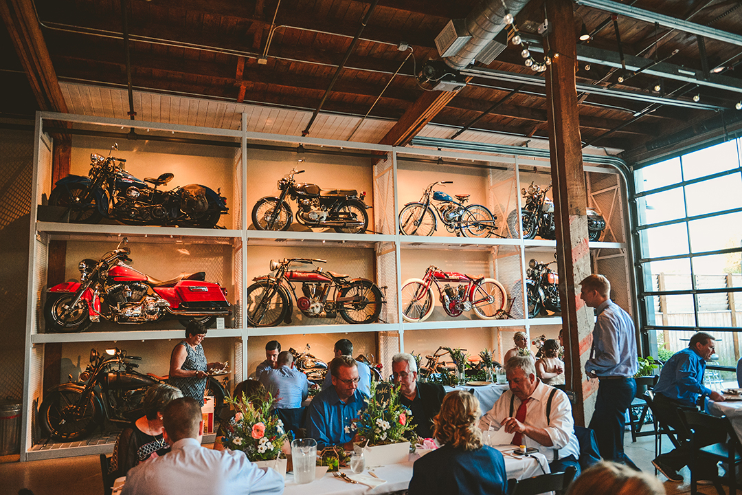 motorcycles on display at a wedding reception with people eating viewed from the eyes of a Naperville Wedding Photographer