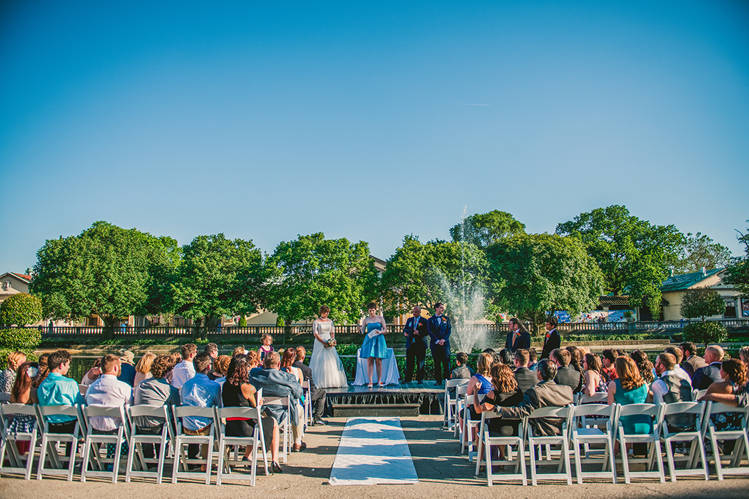 wedding in front of fountain with blue sky at the Brookfield Zoo