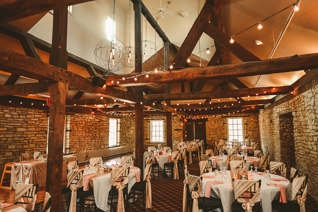 a room setup for a wedding reception with large wooden beams
