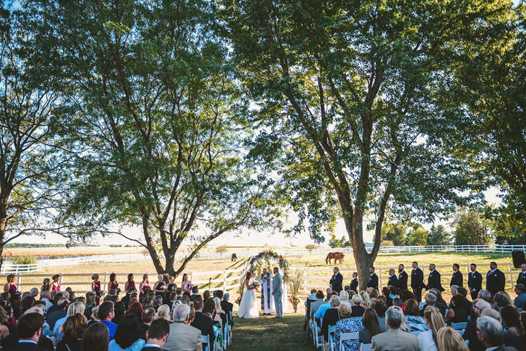 a crowd watches as a man and a woman get married during their Northfork Farm Wedding