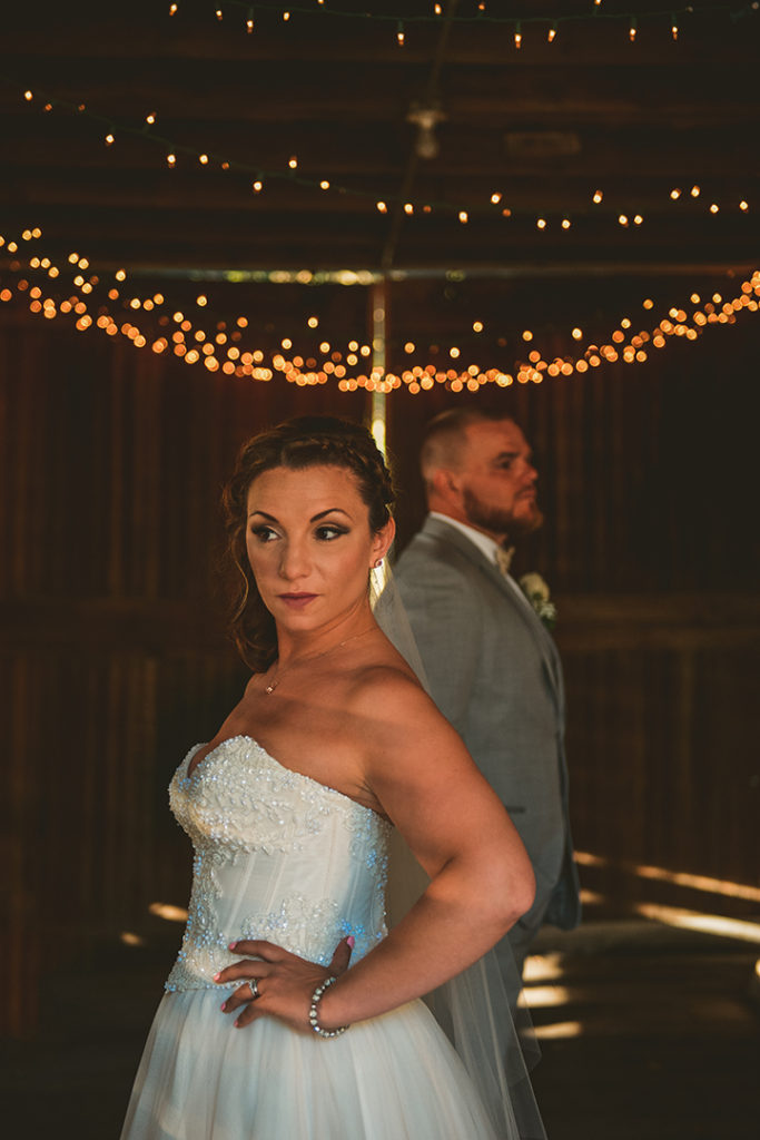 a bride and groom stands in a vintage barn at their Northfork Farm Wedding