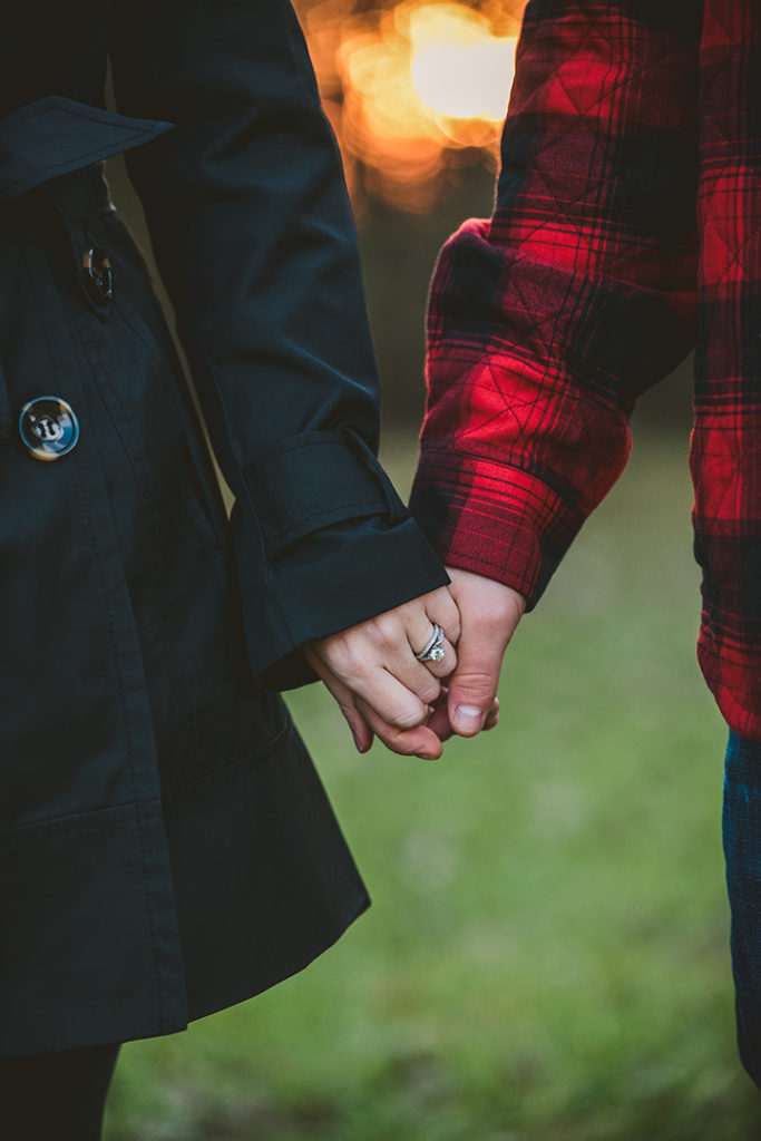 husband and wife holding hands showing off engagement ring