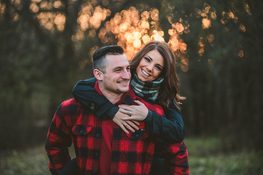 bride on grooms back smiling during a holiday photography session