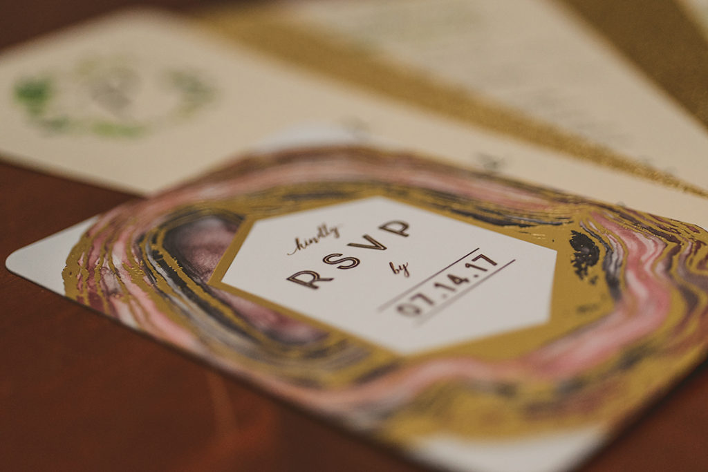 wedding invitations laid out on dark wooden table