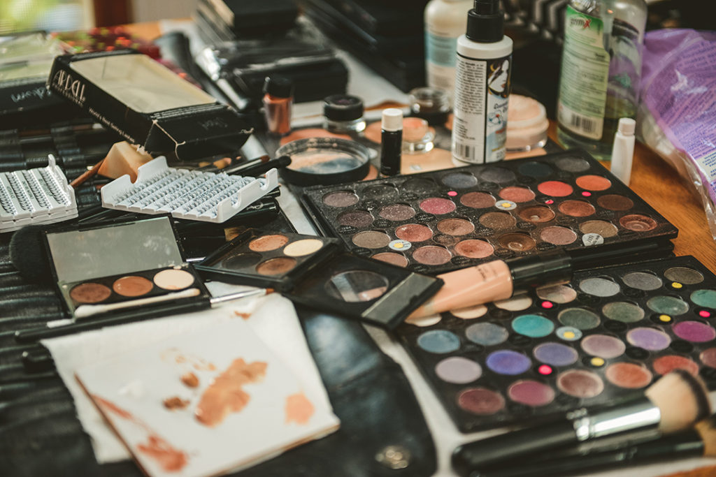 makeup laid out on wooden table at brides house