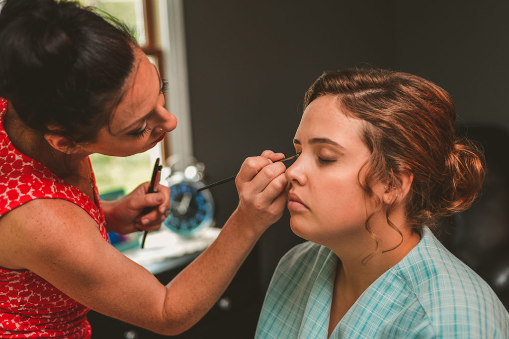 makeup artist applying brides make up at her home in Napervile