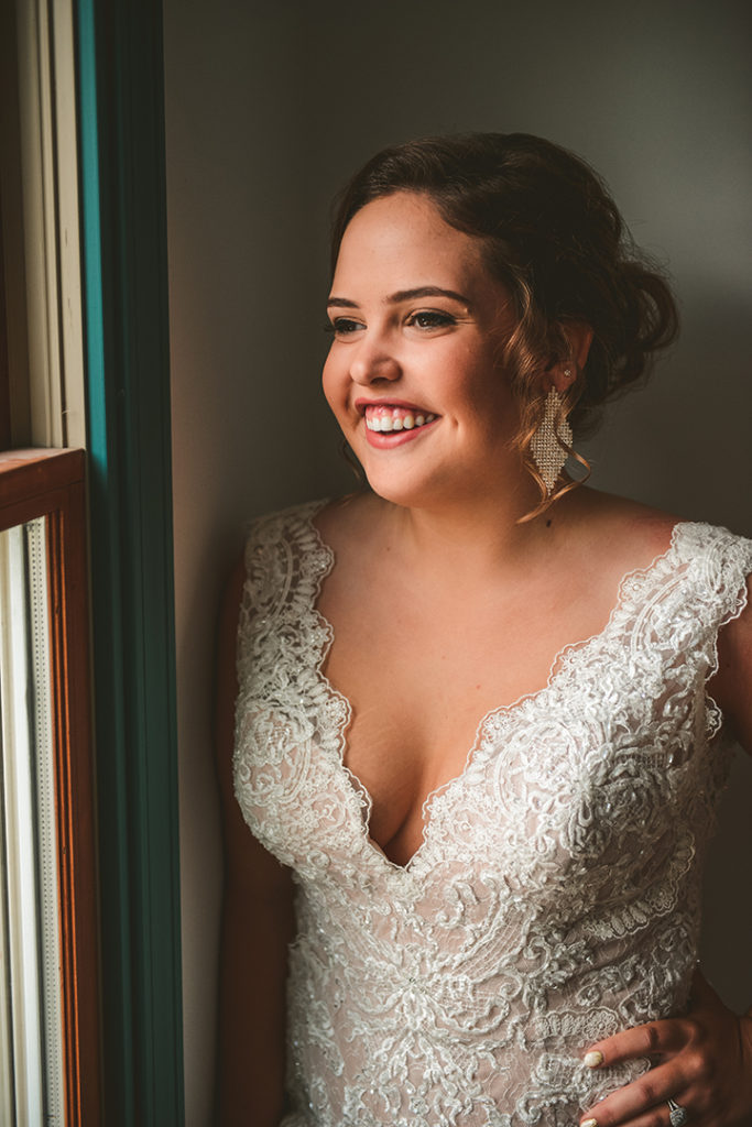 a bride looking out the window with a beautiful smile