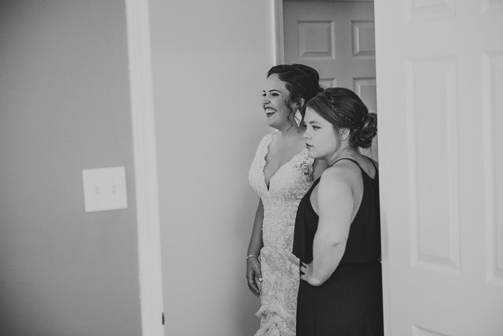a bride laughing in a hallway with her bridesmaids