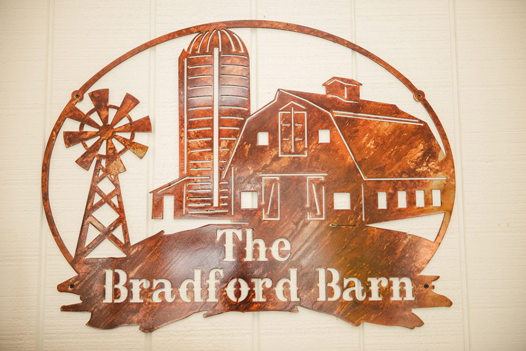 a rusty metal sign of The Bradford Barn logo