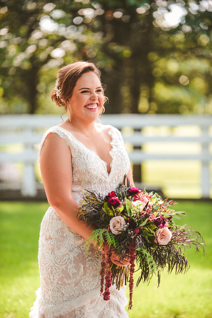 a bride in a beautiful laced wedding dress with real flower bouquet 