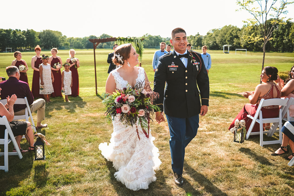 the bride and groom walking down the aisle laughing after getting married 