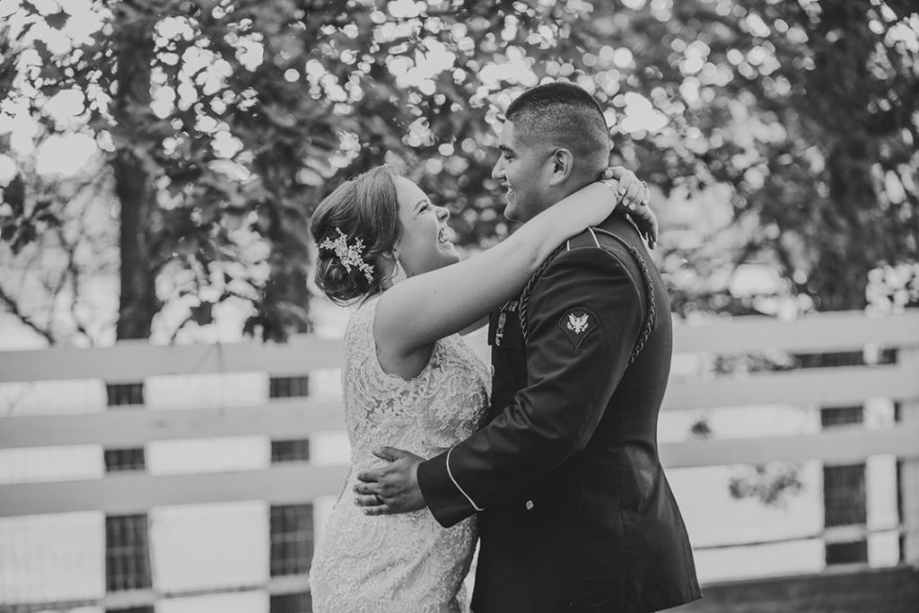 a wedding couple hugging each other as they laugh in a park at Olympia Fields