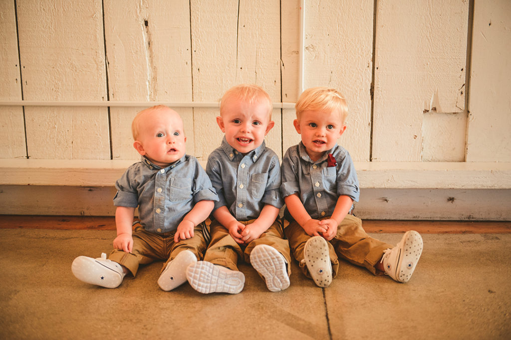 three little boys dressed in blue shirts smiling at the camera during a Olympia Fields wedding reception