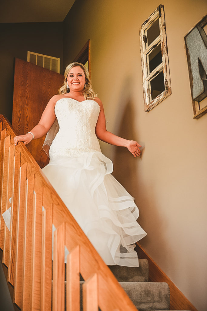 a bride coming down the stairs in her beautiful white wedding dress