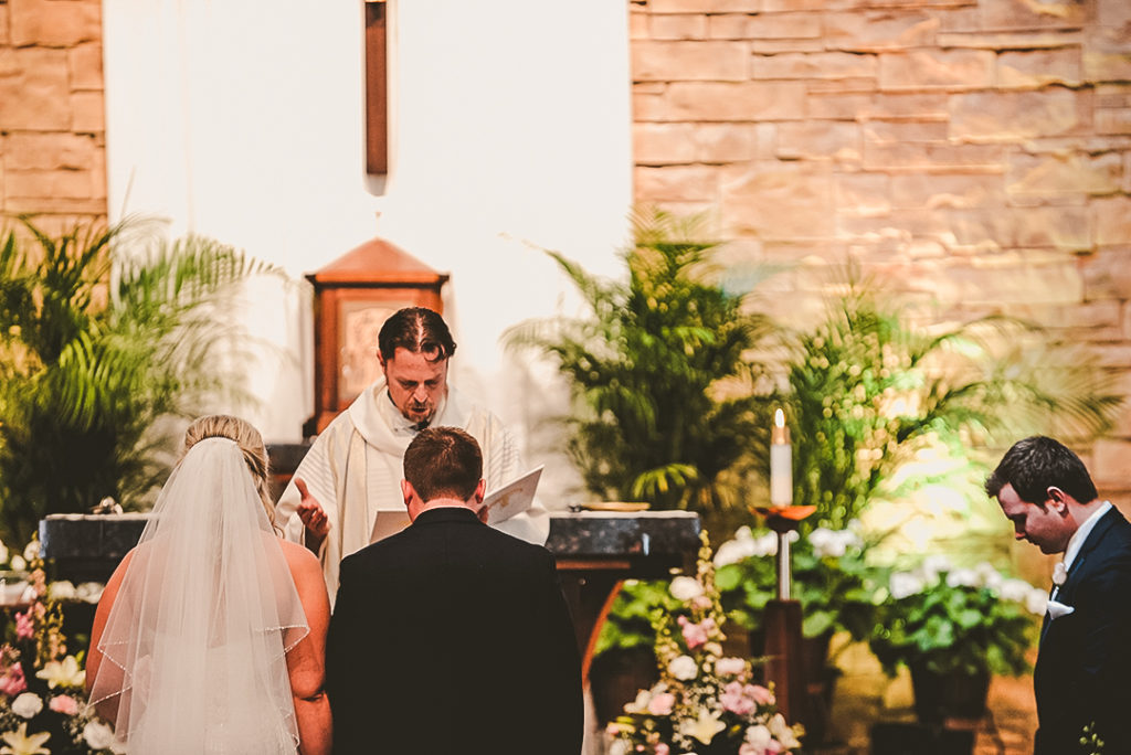 the priest at a wedding reading from the bible at the Immaculate Conception in Morris