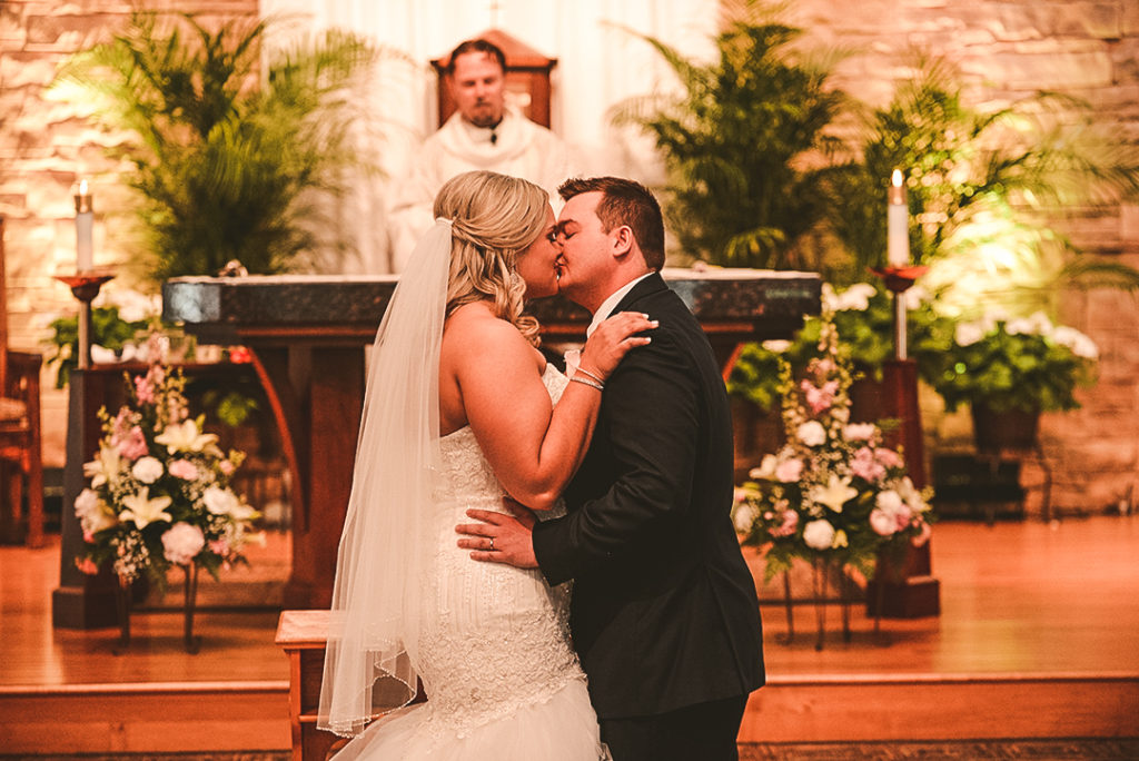 a bride and groom kissing for the first time as husband and wife at a Morris church