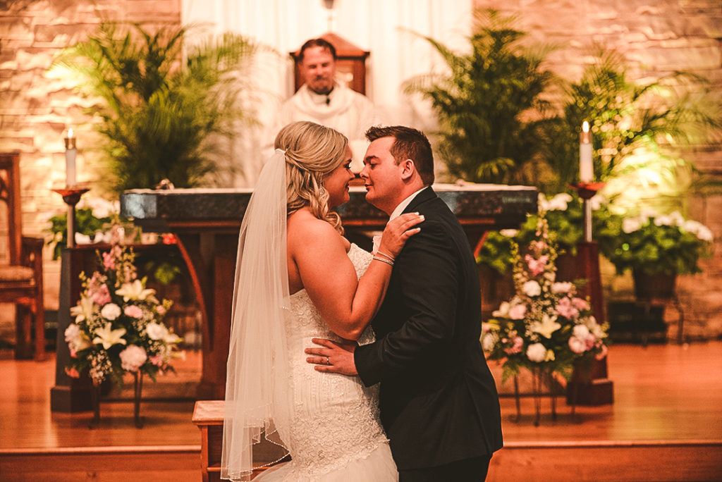 a bride and groom smiling after their first kiss at the church alter