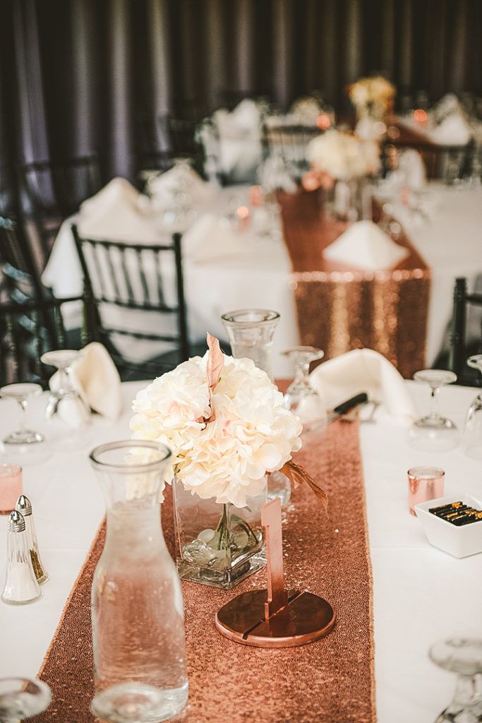 a floral center piece by place settings at a golf course wedding