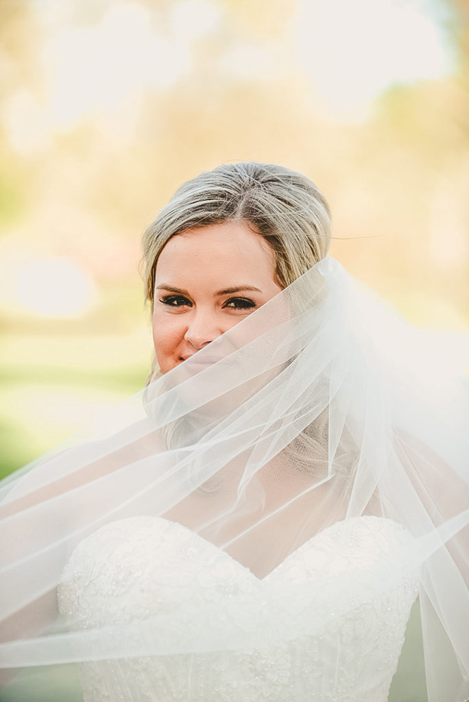 the bride smirking with her vail across her face