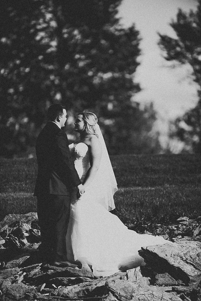 the bride and groom holding hands as they look into each others eyes at the Morris Country Club