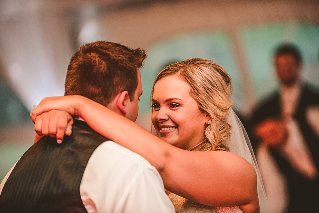 a bride smiling at her husband while they dance at the Morris Country Club